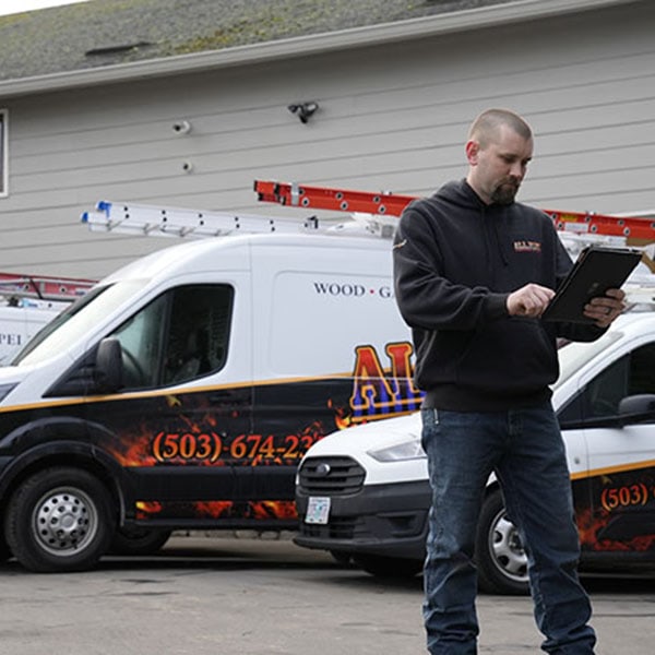 HVAC technician on an ipad standing next to a work vehicle.