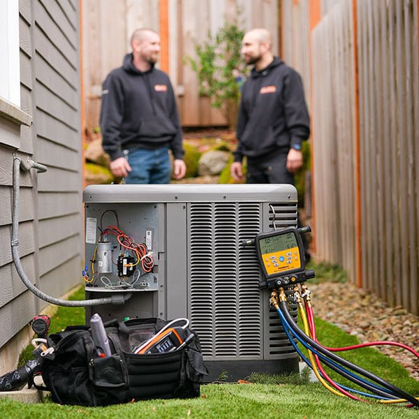 HVAC technician on an ipad standing next to a work vehicle.