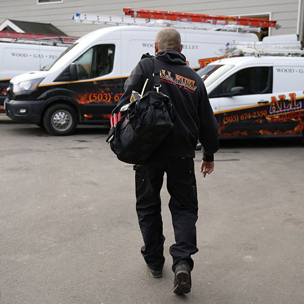 HVAC technician with his tool bag walking to his work vehicle.