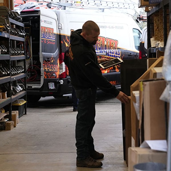 HVAC technician in the company shop looking at inventory.