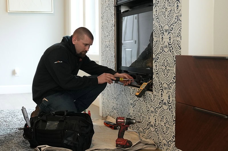 All Fuel technician working on fireplace.