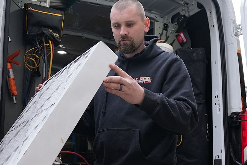 All Fuel technician holding air filter.