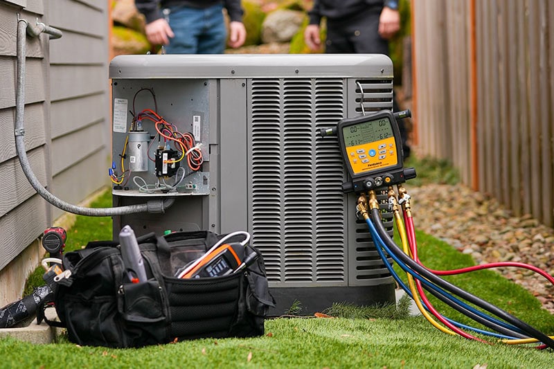 HVAC technicians tools sitting next to a system.