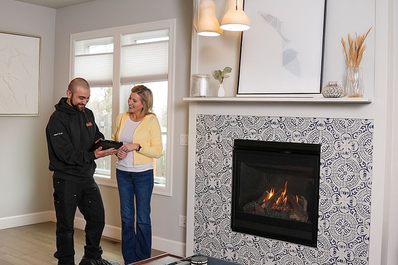 How to Keep Your Gresham, Fireplace in Top Shape. A homeowner talking to a technician.
