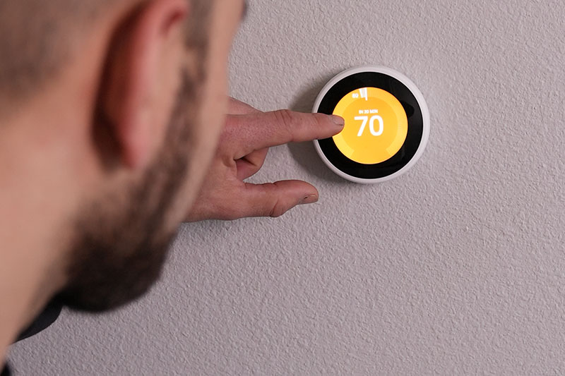 HVAC technician testing out a newly installed smart thermostat.
