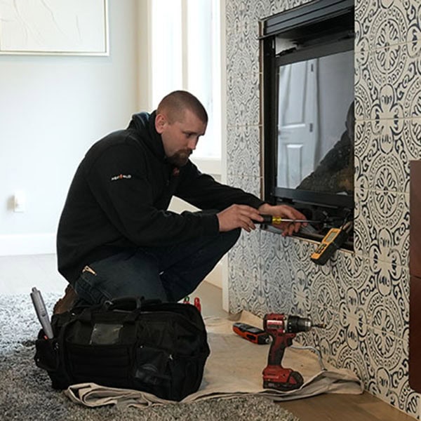 An HVAC technician showing a homeowner his ipad after a completed fireplace installation.