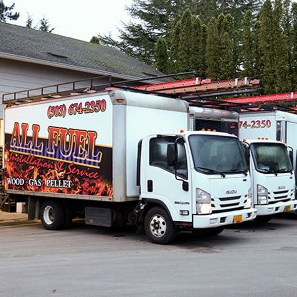 Three All Fuel work vehicles parked outside the shop.