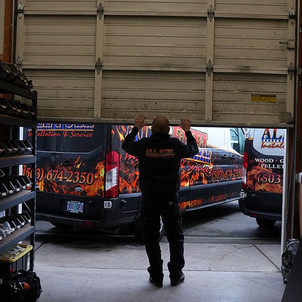 HVAC technician closing the garage door to the company shop.